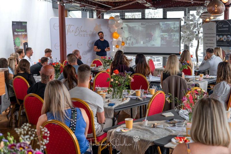 Prelegent przemawia do pełnej sali podczas spotkania The Bloom Up Network